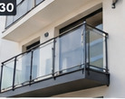 Ilustracja wygenerowana przez AI: szklany balkon domu z metalowymi mocowaniami. Nie jest zdjęciem realizacji MSW.